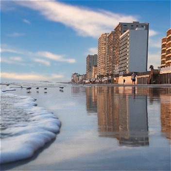 Daytona Beach view of the beach with birds walking and buildings in the background